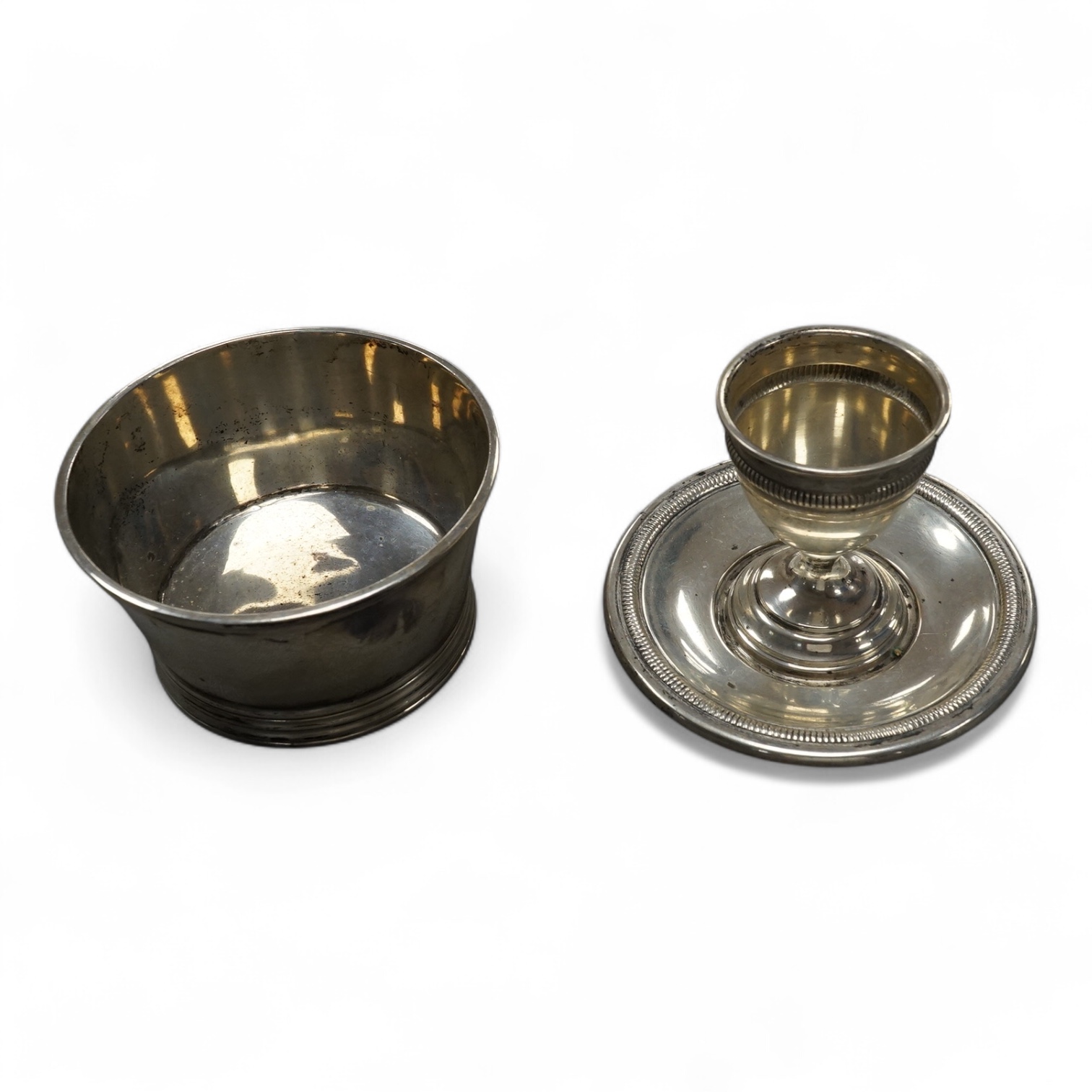 A George VI silver small bowl, Thomas Ducrow & Sons, Birmingham, 1943, diameter 89mm, together with an 800 standard white metal egg cup on fixed stand. Condition - fair to good